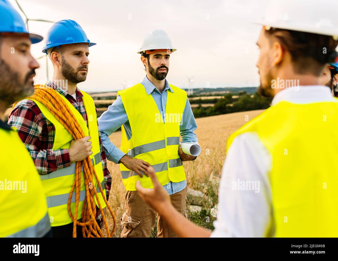 Techniker und Ingenieure im Gespräch mit Windenergieanlagen Stockfoto