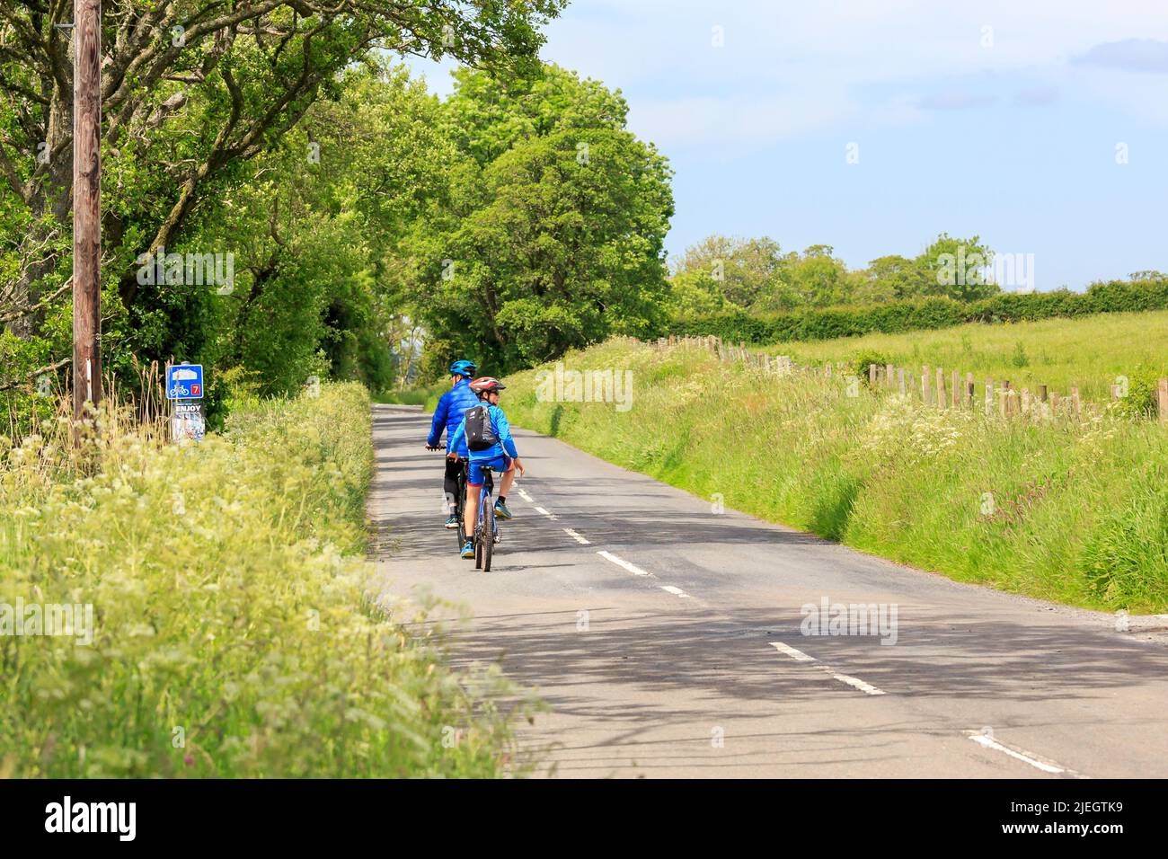 Glencaple, Schottland - 5. Juni 2022 : zwei Radfahrer mit blauen Spitzen auf dem Weg zum Dorf Glencaple, Dumfries und Galloway Stockfoto