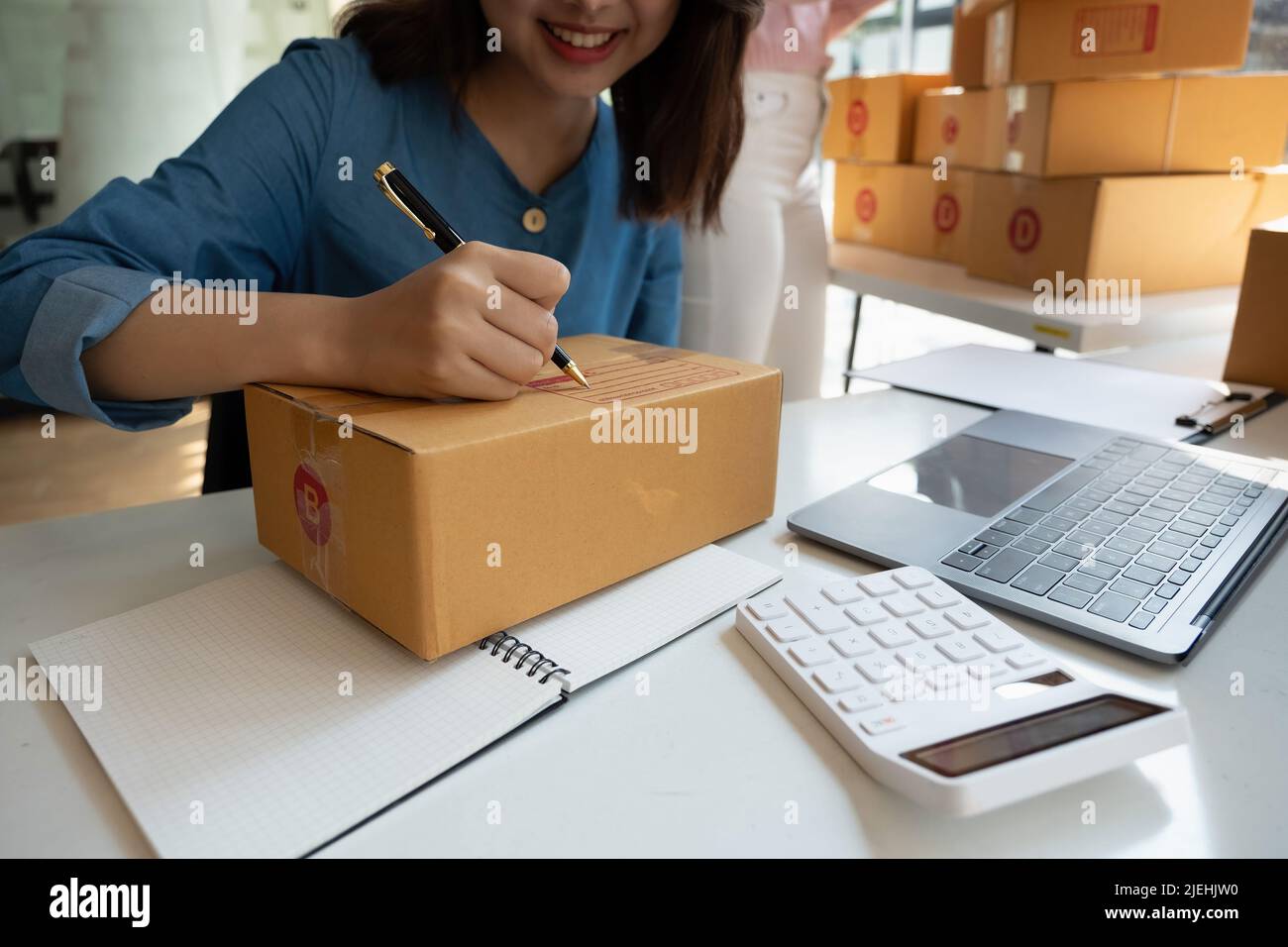 Close up Hand der jungen Frau Kleinunternehmen Eigentümer Online-Shopping zu Hause Vorbereitung Paket Produkt auf Hintergrund. KMU-Unternehmer oder freiberufliches Leben Stockfoto