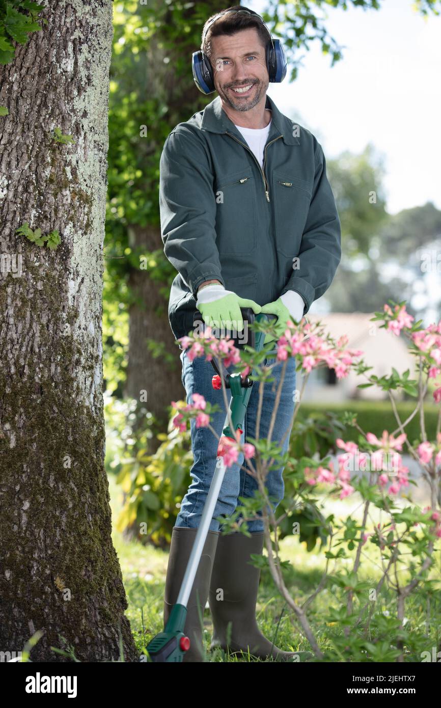 Mann mit Strimmer im Garten Stockfoto