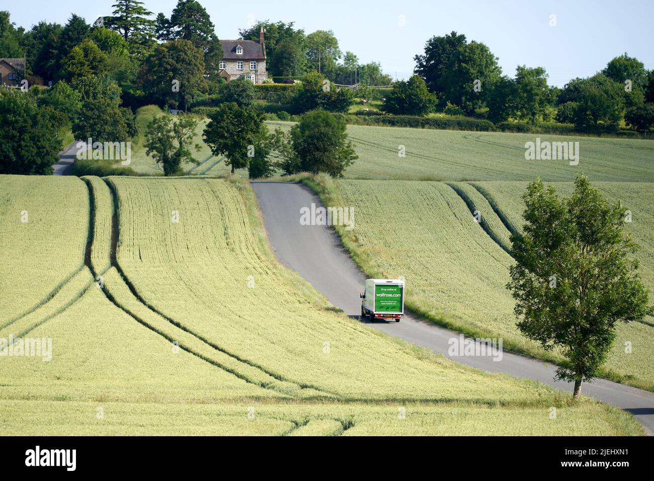 Ein Waitrose-Lieferwagen macht sich den Weg durch die Landschaft zu einem Make-a-Online-Supermarkt Lieferung bei einem Kunden nach Hause Stockfoto