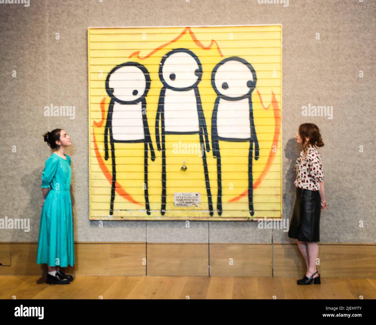 London UK 27 June 2022 Children of Fire, ein großes Kunstwerk des Straßenkünstlers STIK, Verkauf von Post-war & Contemporary Art am Donnerstag, 30. Juni in der New Bond Street, London. STIK schuf das Werk nach den Londoner Krawallen im Jahr 2011, das auf das Garagentor eines veganen Gemeindezentrums in Hackney gesprüht wurde. Es hat eine Schätzung vor dem Verkauf von £120.000-180.000 – die höchste Schätzung, die einem Werk des Künstlers gegeben wurde. Paul Quezada-Neiman/ Alamy Live News Stockfoto