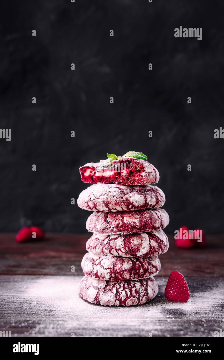 Stapel oder Turm von Keksen. Rote Samtkeks. Köche Hände mit kleinem Sieb zum Backen bestreuen Puderzucker. Baker dekorieren und bestreuen stac Stockfoto