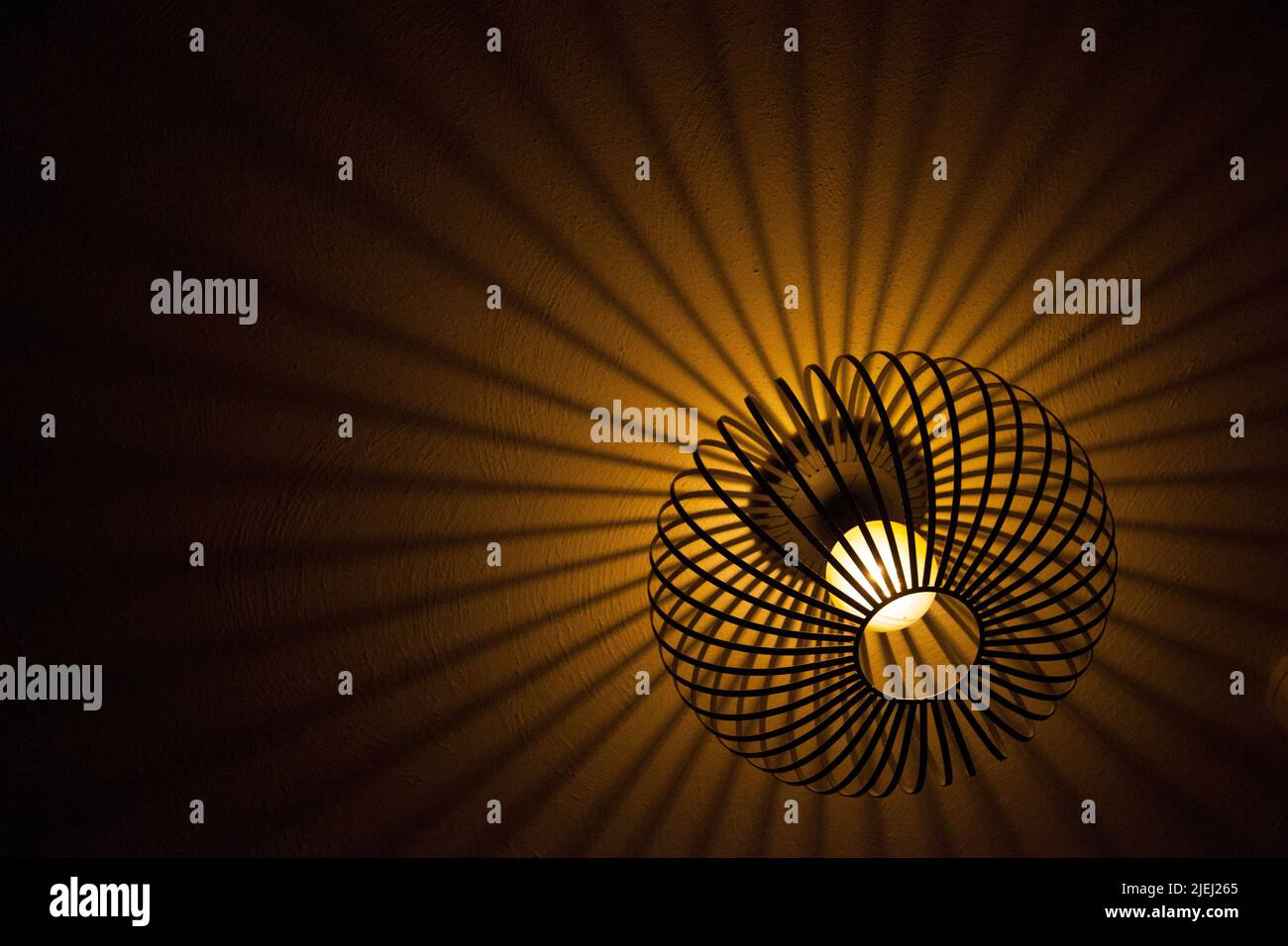Ein Lampenschirm mit kreisförmigem Rahmen und strahlenähnlichen Schatten Stockfoto