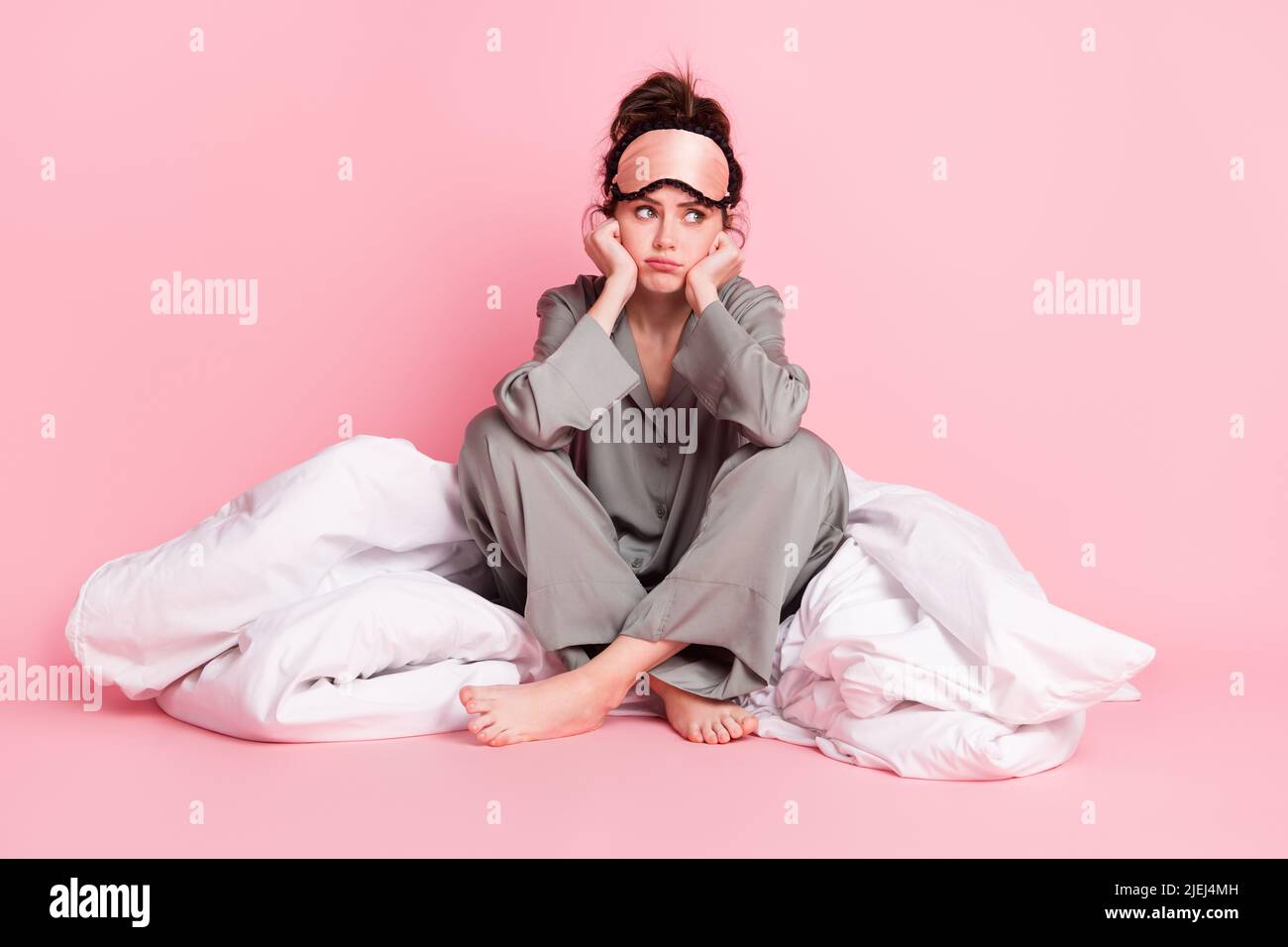 In voller Größe Foto von unzufriedenen Dame sitzen Arme auf Wangen suchen leeren Raum mürrisch Gesicht isoliert auf rosa Hintergrund Stockfoto
