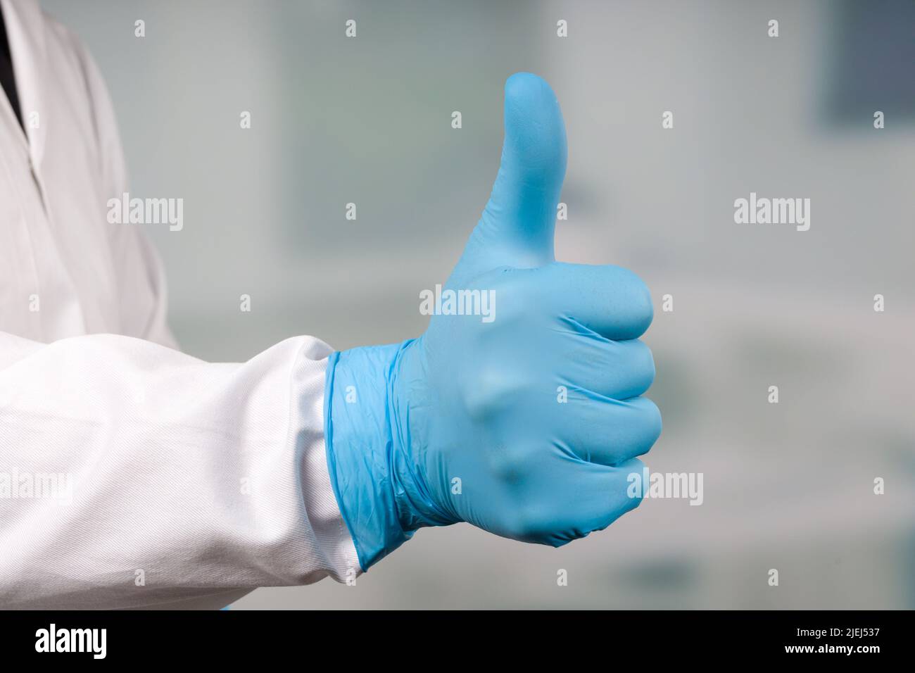 Nahaufnahme der Hände in medizinischen Handschuhen zeigt Daumen nach oben Stockfoto