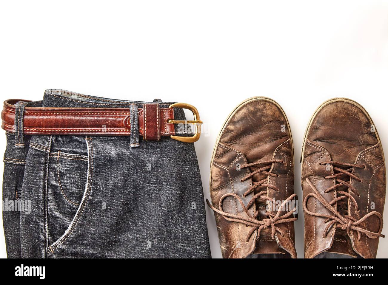 Stilvoll verzweifelte Vintage braune Lederschuhe und schwarze Jeans auf weißem Hintergrund isoliert Stockfoto