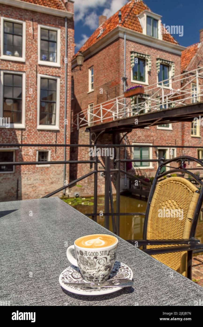 Appingedam, Niederlande - 2. Juni 2022: Frische Tasse Kaffee auf einer sonnigen Café-Terrasse im historischen Zentrum von Appingedam in Groningen Stockfoto