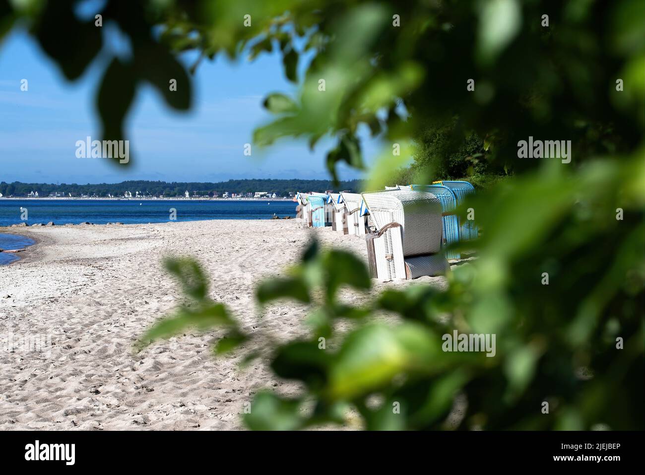 Traditionelle Strandliegen am ostseestrand vor blauem Himmel am sonnigen Sommertag Stockfoto