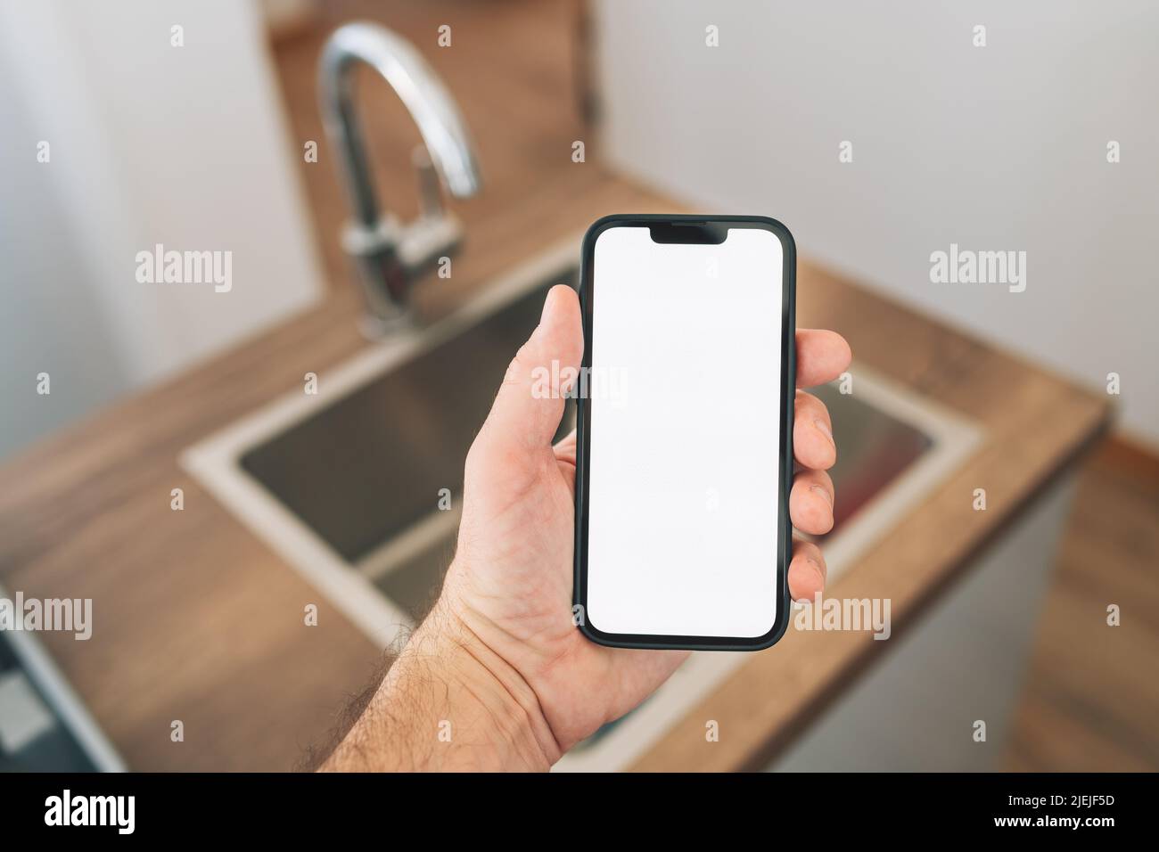 Smart-Home-Smartphone-Mockup-Bildschirm vor dem Spülbecken, selektiver Fokus Stockfoto