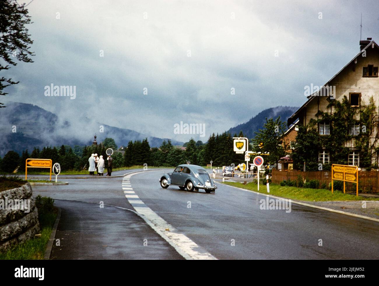 Volkswagen VW-Käfer-Wagen von der Hauptstraße in Richtung Hinterzarten, Baden-Württemberg, Deutschland Juli 1959 Bromley-Roller-Club-Mitglieder an der Ecke diskutieren Stockfoto