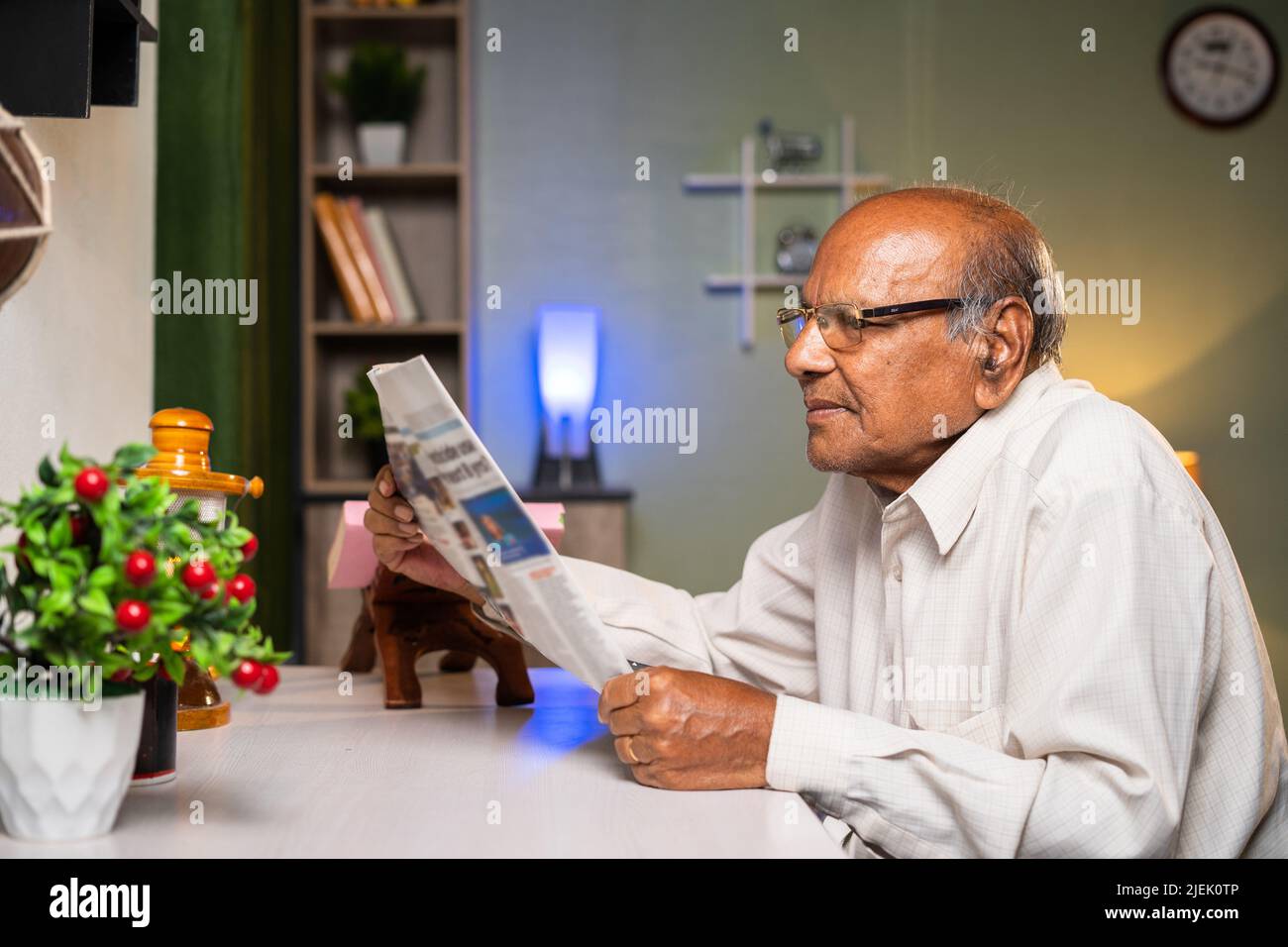 Alter Mann mit Brille liest Zeitung zu Hause - Konzepte von Alltag, Wissen und Entspannung Stockfoto