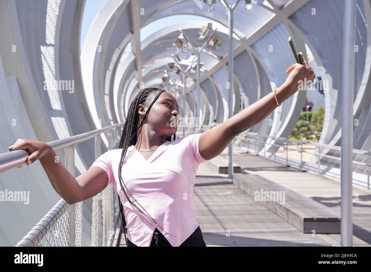 afroamerikanische Frau mit Zöpfen, die mit ihrem Smartphone ein Selfie gemacht hat Stockfoto