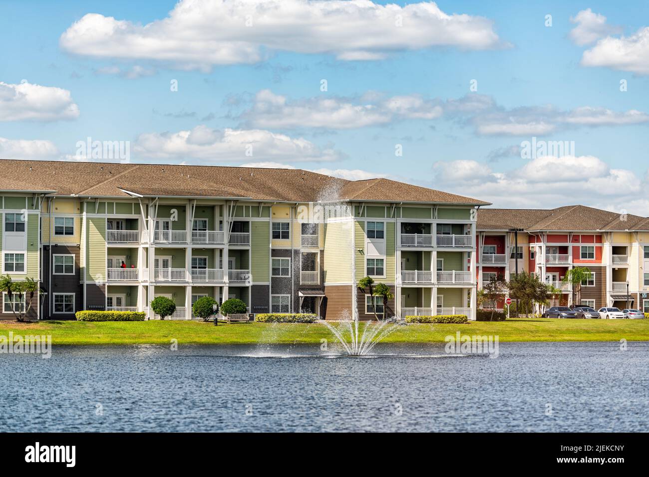 Orlando, Florida Luxus Lifestyle Apartments Gebäude mit drei Etagen am See Wasserbrunnen in tropischer Stadt mit blauen Himmel Wolken Stockfoto