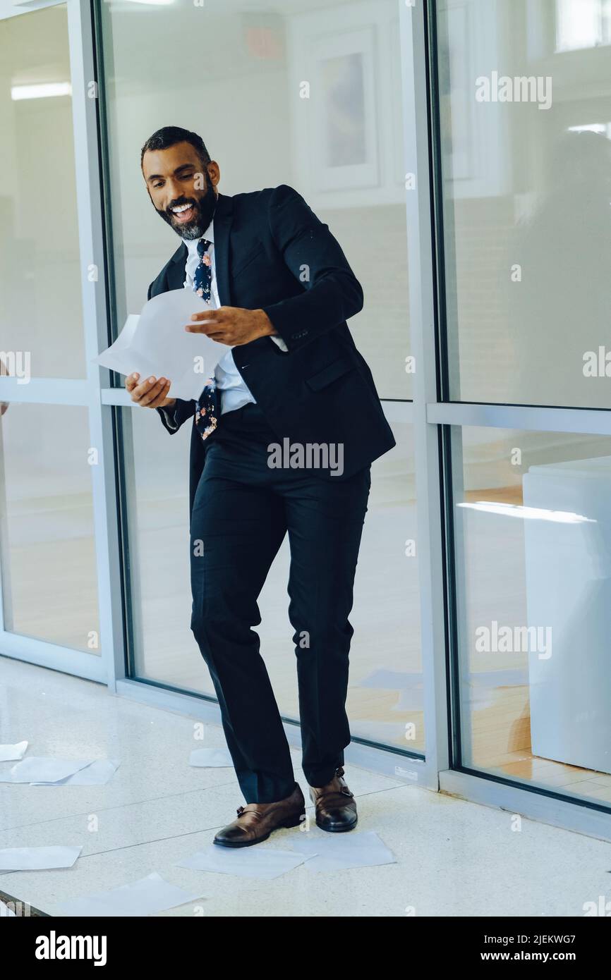 Geschäftsstress überwältigte afroamerikanischen Geschäftsmann warf Papiere in der Luft Büro Schuss Stockfoto