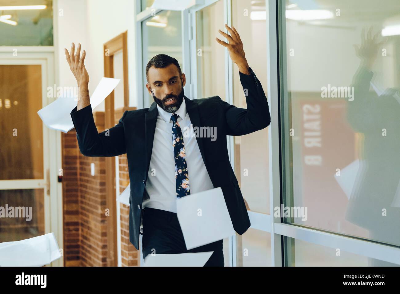 Geschäftsstress überwältigte afroamerikanischen Geschäftsmann warf Papiere in der Luft Büro Schuss Stockfoto