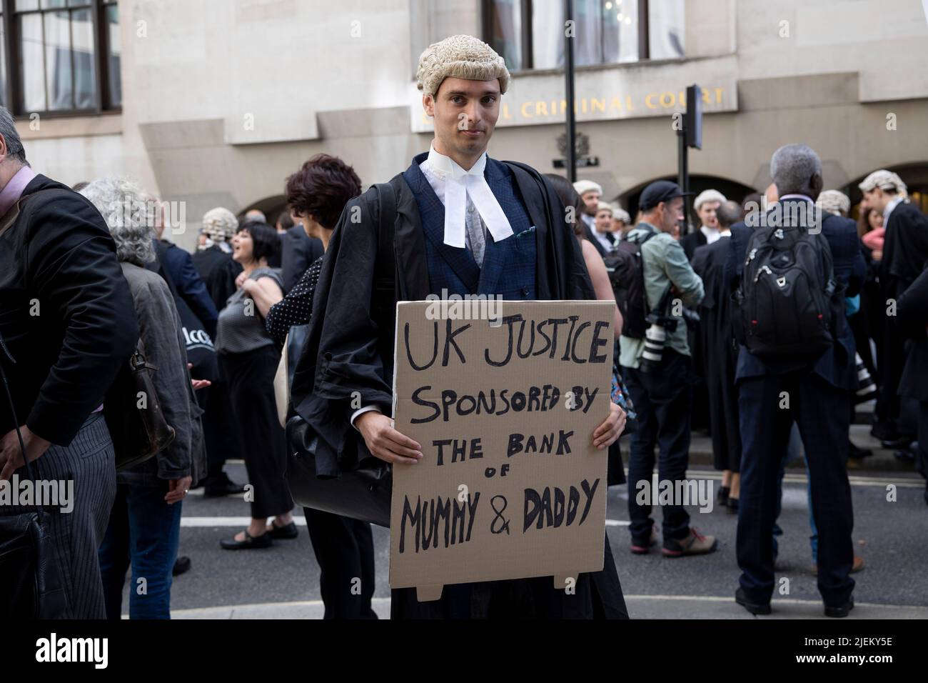 Ein Junior-Krimineller hält während der Streikaktion vor dem Old Bailey ein Plakat. Kriminelle Barrists treten bei Streiks im Vereinigten Königreich wegen Lohnstreits vor Gericht aus. Die Criminal Bar Association (CBA) sagte, dass die Einkommen für kriminelle Junior-Barristers in den letzten 20 Jahren um 30 % gesunken sind und nach Ausgaben von £12200 in den ersten 3 Jahren der Praxis zu einem durchschnittlichen Einkommen geführt haben. Sie fordern eine Erhöhung der Anwaltskosten um 25 %, was über dem von der Strafrecht-Überprüfung im vergangenen Dezember veröffentlichten Mindestwert von 15 % liegt. Stockfoto