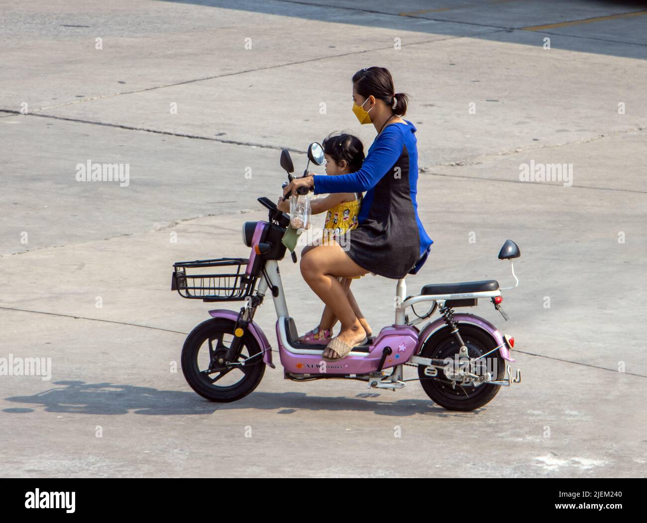 SAMUT PRAKAN, THAILAND, APR 07 2022, Eine Frau fährt mit einem kleinen Mädchen auf einem elektrischen Zweisitzer-Roller Stockfoto
