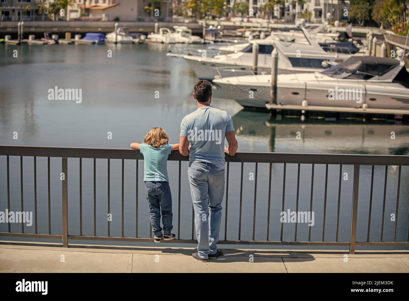 Elternschaft und Vaterschaft. Vatertag. Vater und Sohn blicken auf Yachten im Hafen. Stockfoto
