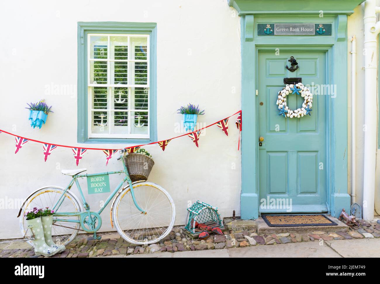 Robin Hood's Bay Yorkshire - hübsches Green Bank Haus, das mit einem grünen Fahrrad und einem Kranz an der Tür von Robin Hood's Bay Yorkshire UK eingerichtet ist Stockfoto