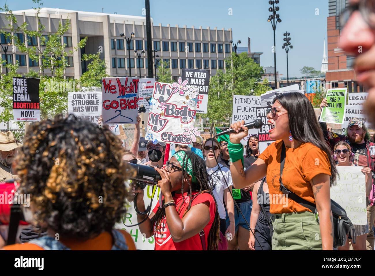 Junge hispanische Frau spricht mit Demonstranten, die bei einer Demonstration gegen das Urteil des Obersten Gerichtshofs für Abtreibung Zeichen halten und Roe v. Wade umstürzen. Stockfoto
