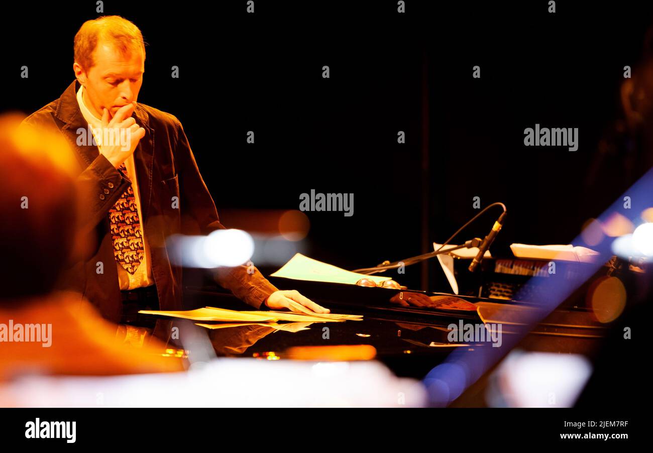 Big Band: Musikalischer Leiter beim Lesen der Partitur. Ein Dirigent, der die Bandpartitur konsultiert. Aus einer Reihe von Bildern von Musikern in einer Swing Jazz Band. Stockfoto