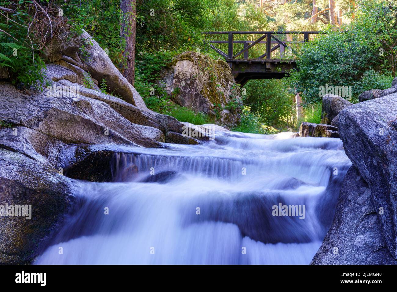 Mehrere Wasserfälle unter einer Holzbrücke. Navacerrada. Stockfoto