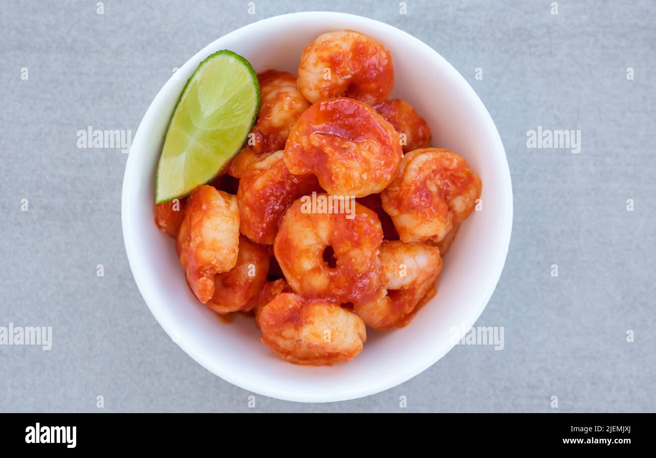 Tomaten-Knoblauch-Garnelen mit Limettenkeil in der Schüssel Stockfoto