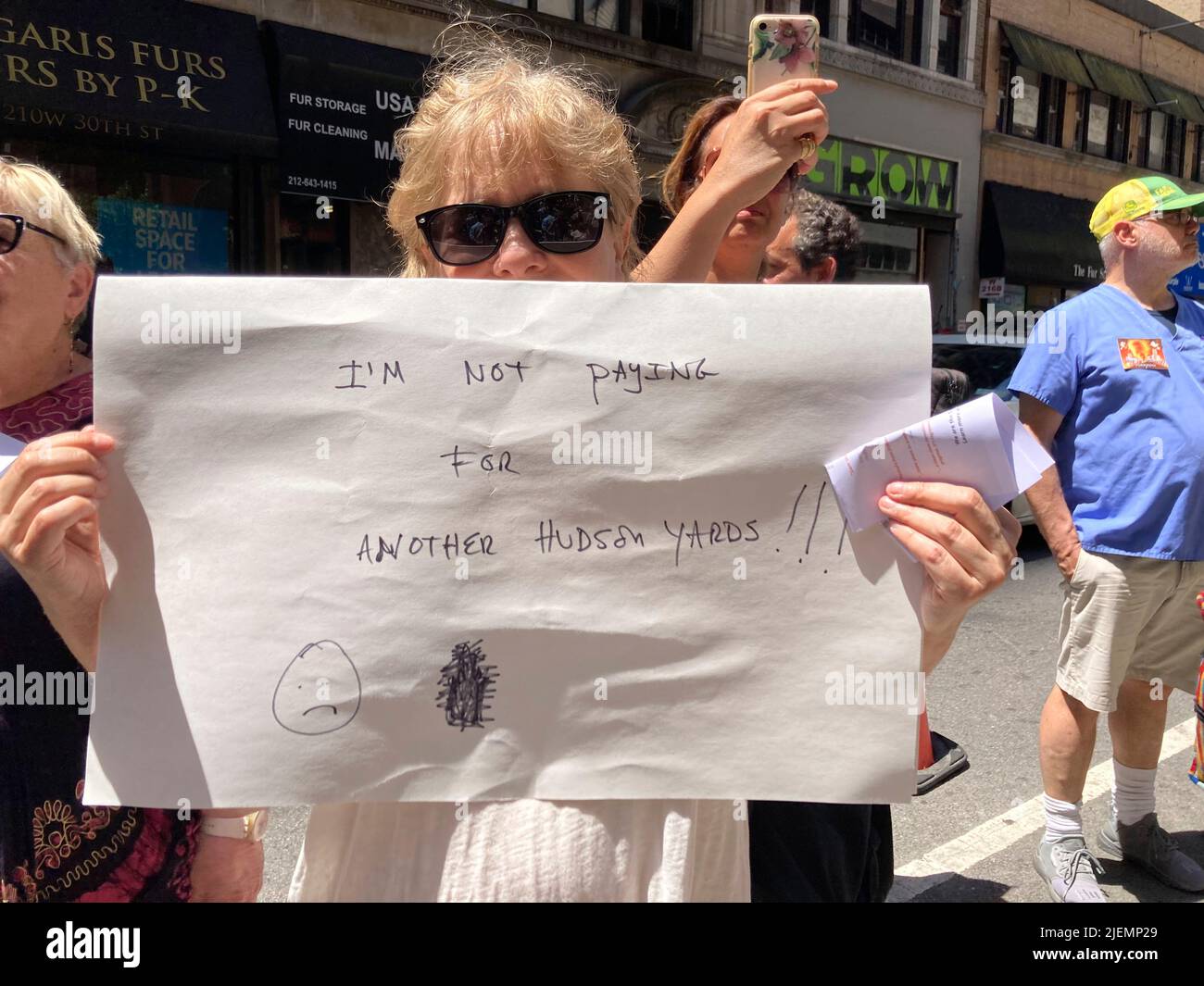 Demonstranten versammeln sich vor dem St. John the Baptist R.C. Kirche am Mittwoch, den 15. Juni 2022 in der Nähe der Pennsylvania Station in New York, um ihre Bedenken über den geplanten „Empire Station Complex“ zu äußern. Das Projekt zur Stadterneuerung würde eineinhalb Blocks um die Penn Station, einschließlich der historischen Kirche, über einen bedeutenden Bereich ergreifen und Unternehmen und Bewohner verdrängen. (© Frances M. Roberts) Stockfoto