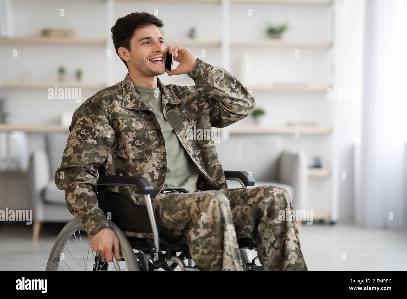 Glücklicher Veteran, der mit seinem Freund Combat telefoniert Stockfoto