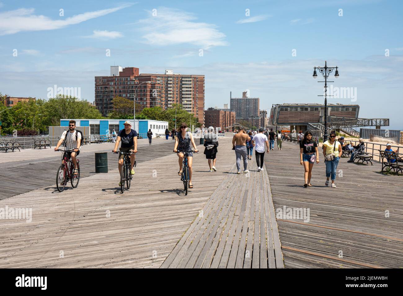 Menschen, die auf dem Riegelmann Boardwalk in Coney Island in Brooklyn, New York City, Vereinigte Staaten von Amerika, Rad fahren Stockfoto