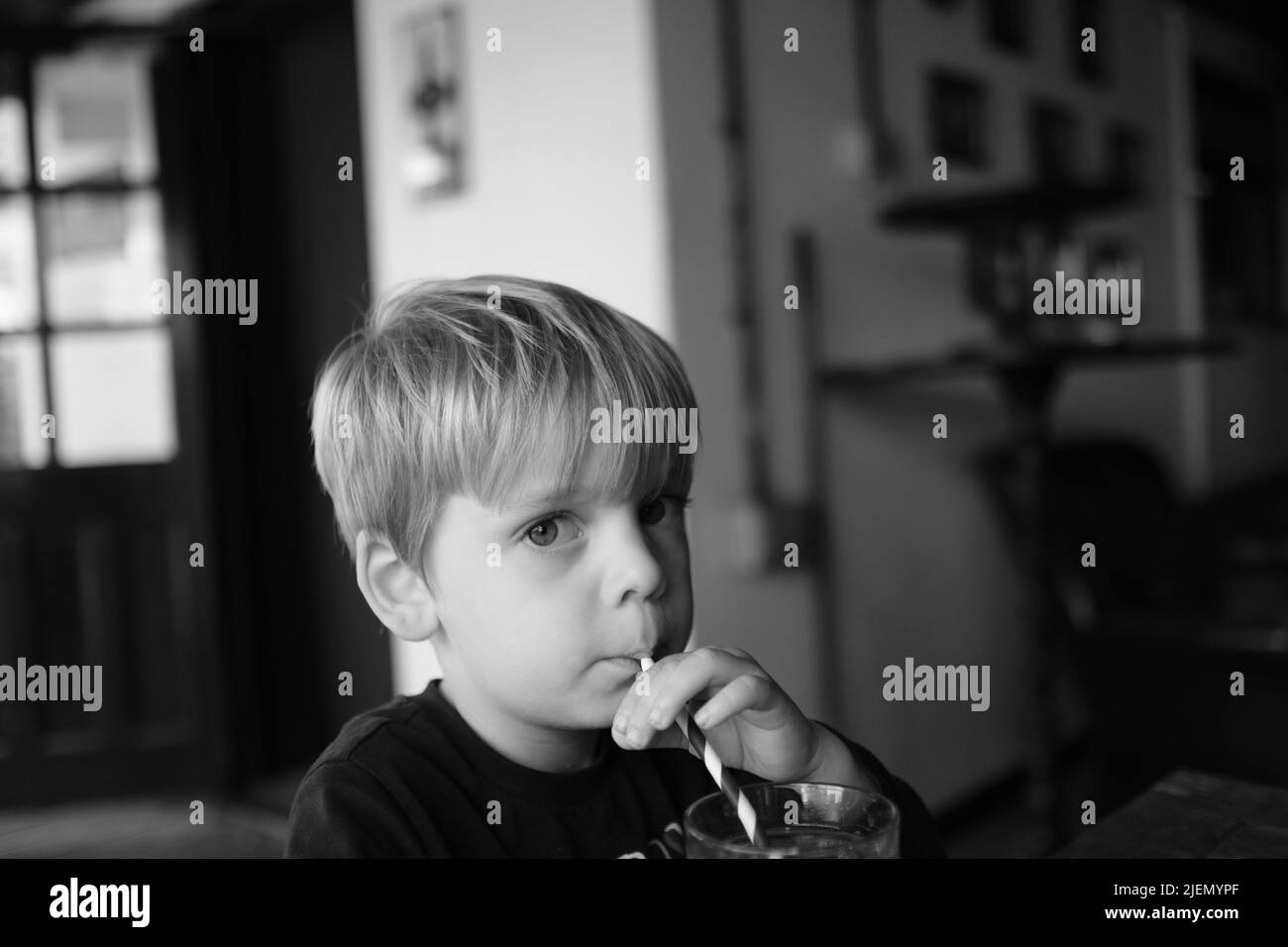 Junge, 3 Jahre alt, trinkt aus einem Strohhalm Stockfoto