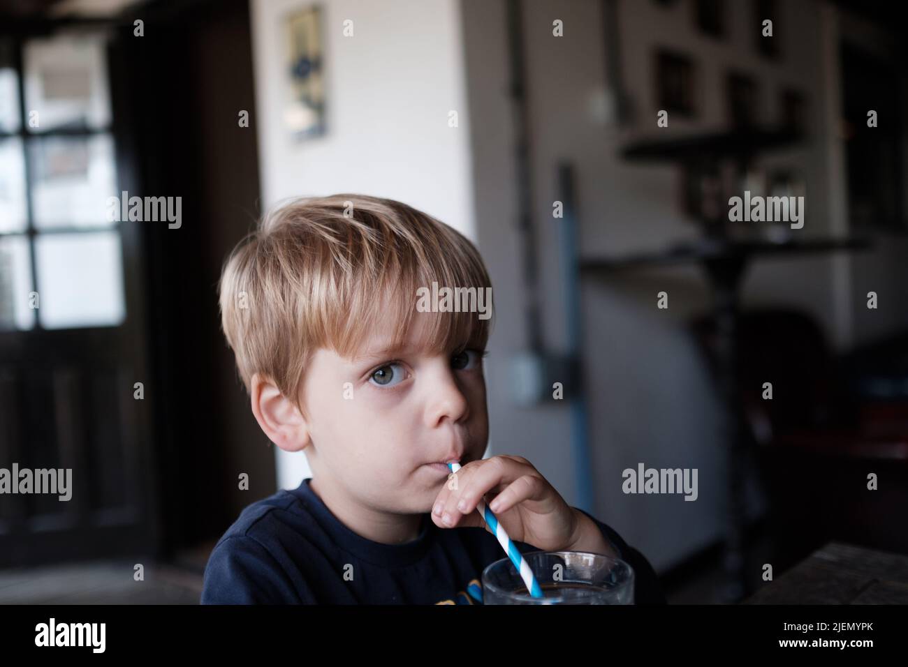 Junge, 3 Jahre alt, trinkt aus einem Strohhalm Stockfoto