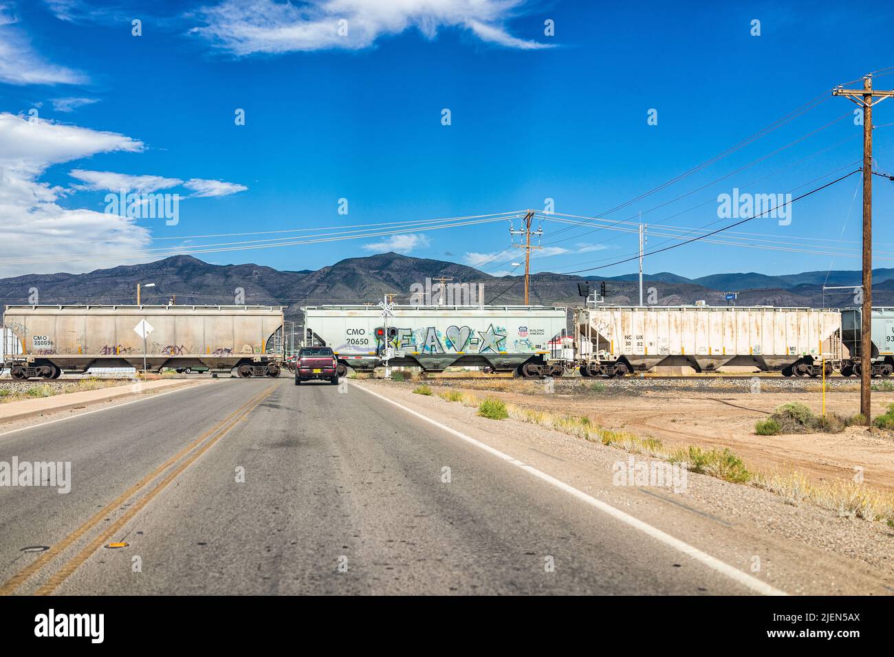 Alamogordo, USA - 9. Juni 2019: Alamogordo, New Mexico City mit Bahnüberfahrt und Auto auf der Straße und Blick auf die Sacramento Berge Stockfoto