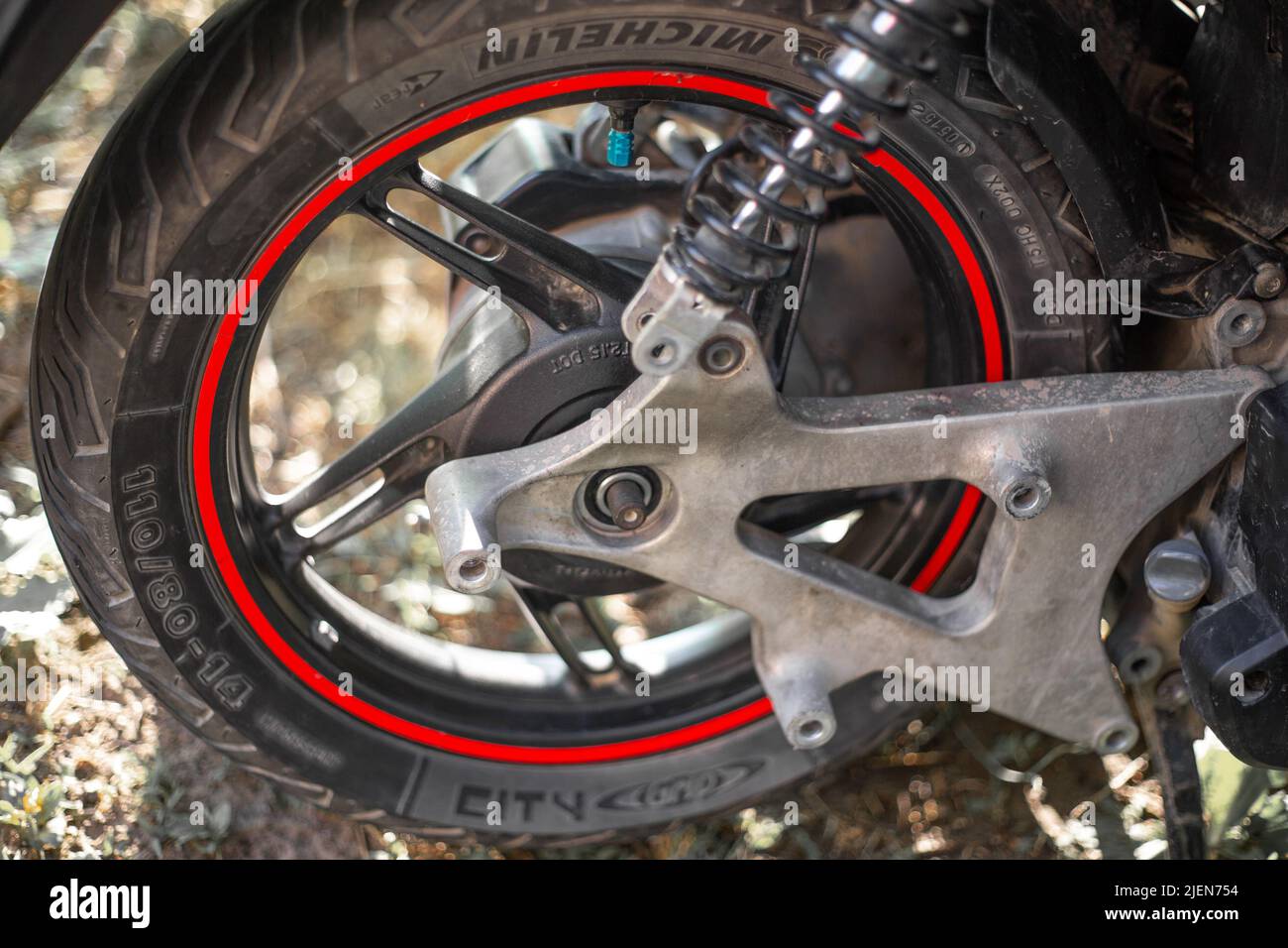 Das Hinterrad eines Motorrads mit Michelin-Reifen und einer zerlegten Gabel. Motorroller reparieren und Bremse austauschen. Russland, Anapa -11,06,2022 Stockfoto