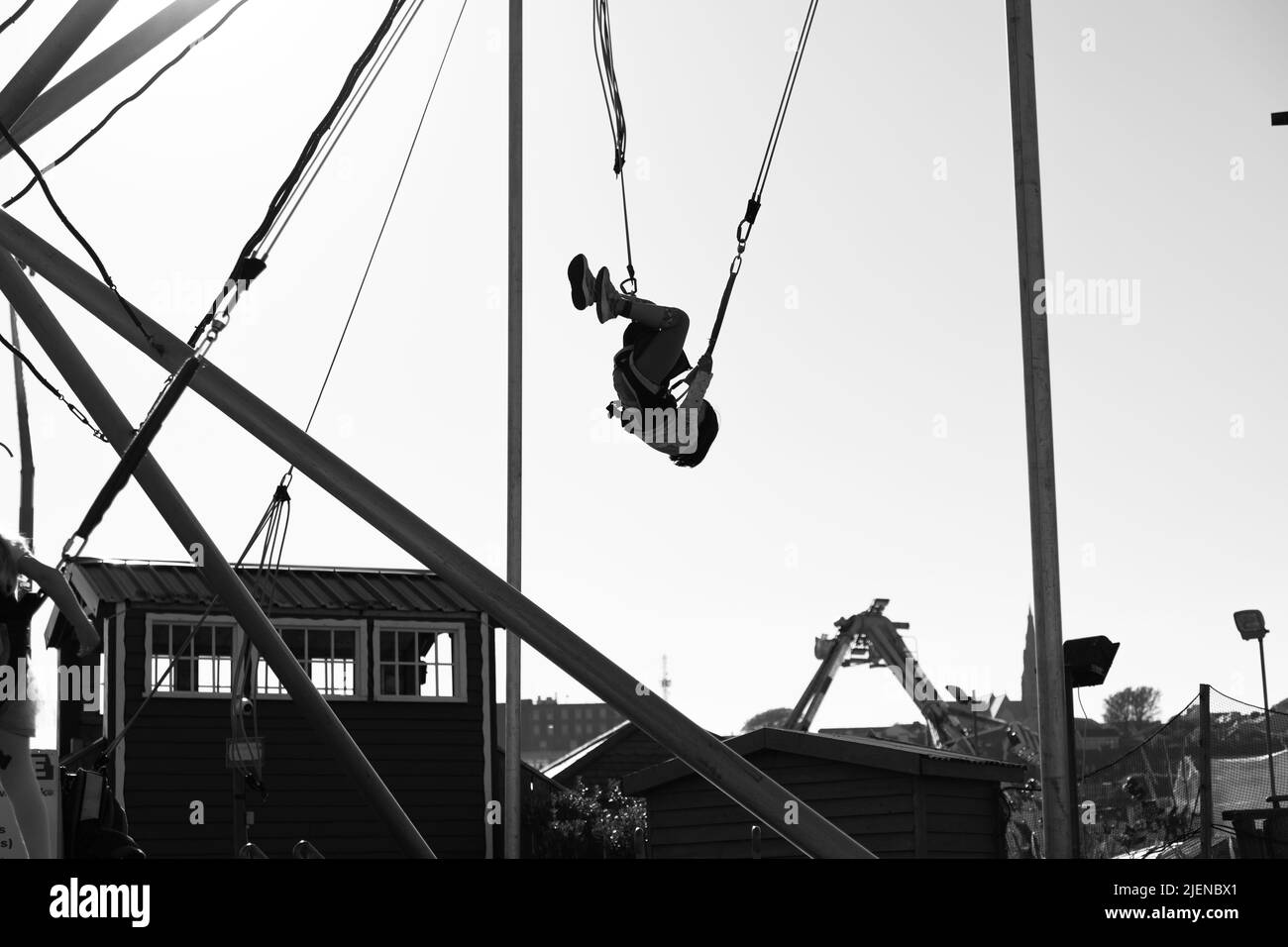 Mädchen springen in einem Vergnügungspark Looping und Spaß haben. Schwarz-Weiß-Fotografie. Tramore, Irland Stockfoto