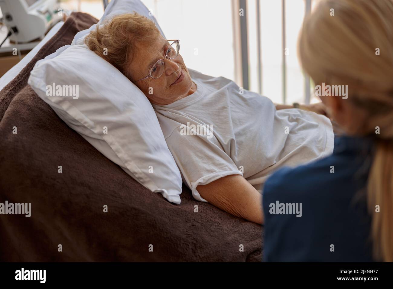 Arzt, der einen kranken Patienten vor medizinischen Eingriffen in einem Krankenhauszimmer unterstützt Stockfoto