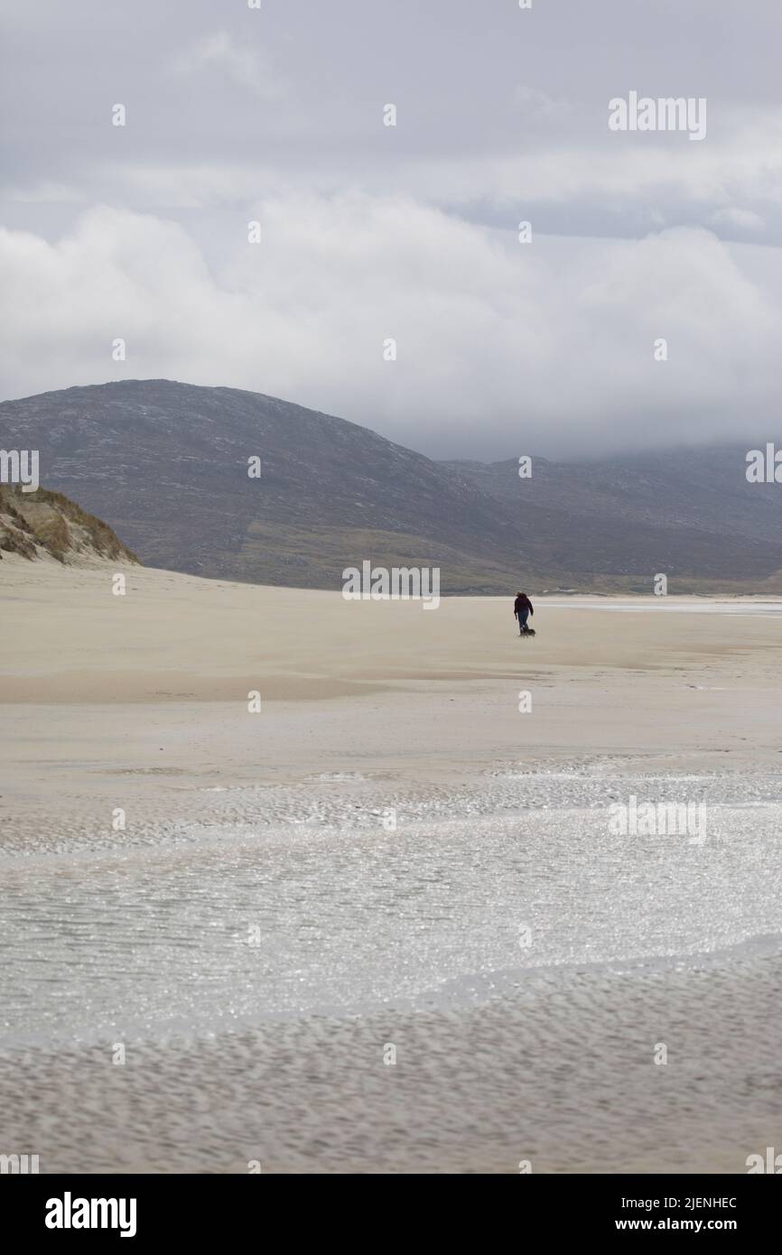 Frau mit ihrem Hund zu einem Spaziergang am Strand von Luskentire auf der Isle of Harris, Äußere Hebriden, Schottland, Großbritannien Stockfoto