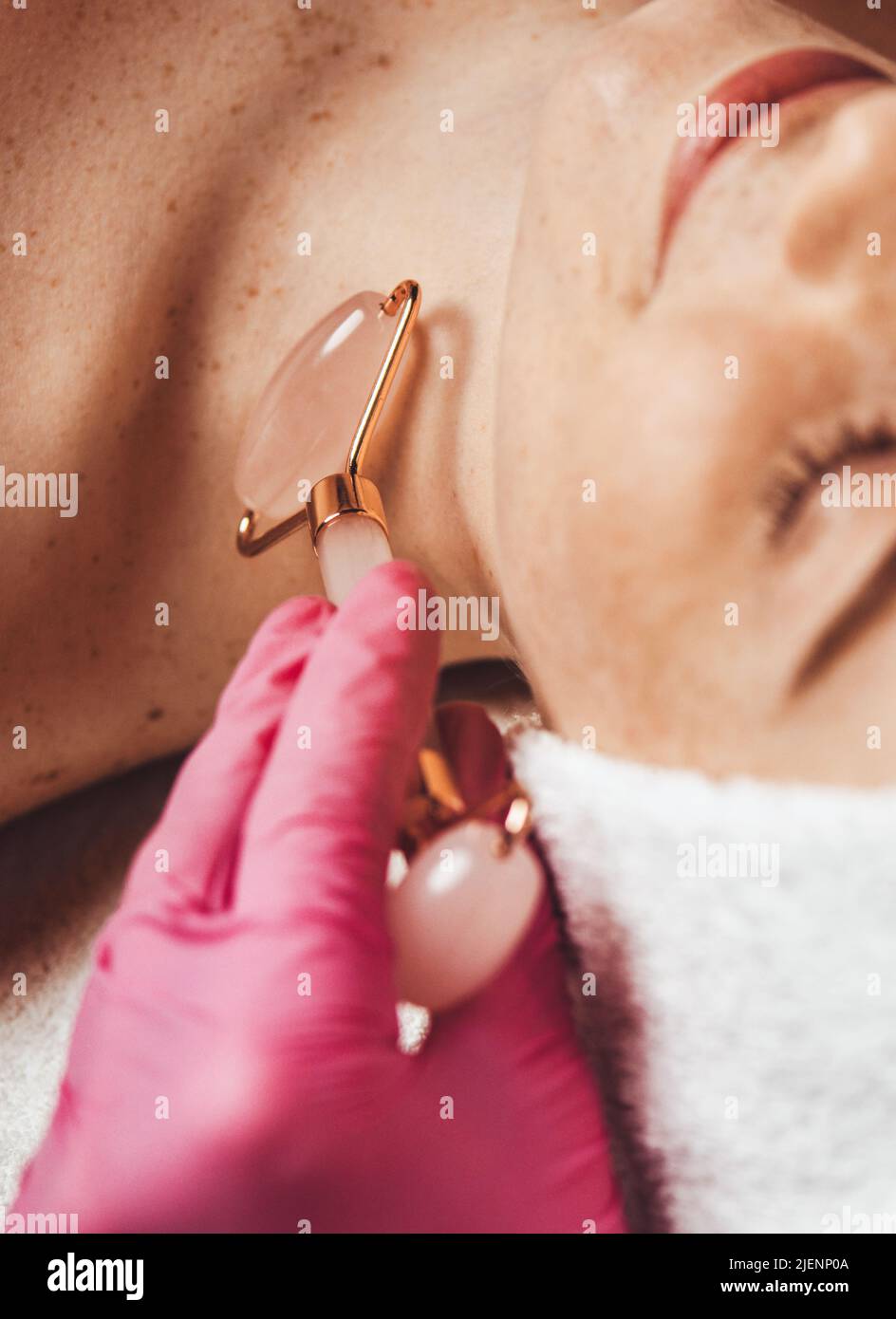 Frau, die eine massierte Gesichtshautbehandlung mit Jaderolle erhält. Gesichtsbehandlung. Beauty Face. Hautpflege. Stockfoto