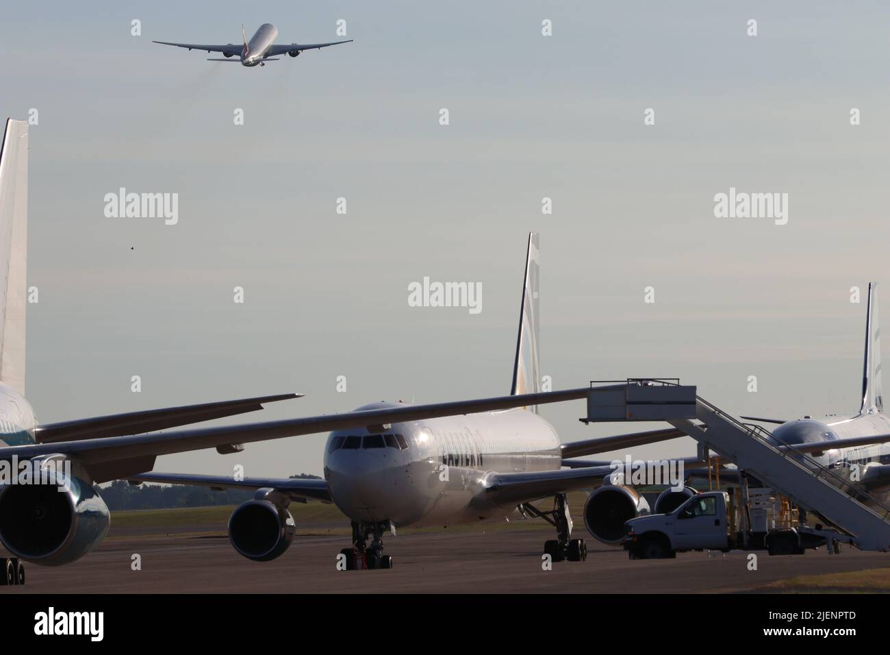 Eine Boeing 777-200ER mit Elementen des Kampfteams der 2. Brigaden und des Bataillons der 101. Hauptquartiere und Hauptquartiere, 101. Airborne Division (Air Assault), startet am 27. Juni vom Campbell Army Airfield, Fort Campbell, Ky. Nach Europa und fliegt über eine Reihe von Flugzeugen, die sich auf den Transport zusätzlicher Soldaten vorbereiten. Stockfoto