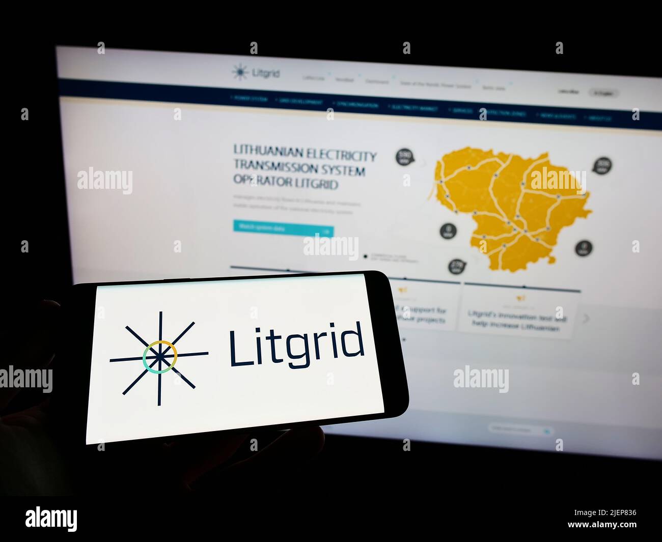 Person, die das Smartphone mit dem Logo des litauischen Elektrizitätsunternehmens Litgrid ab auf dem Bildschirm vor der Website hält. Konzentrieren Sie sich auf die Telefonanzeige. Stockfoto