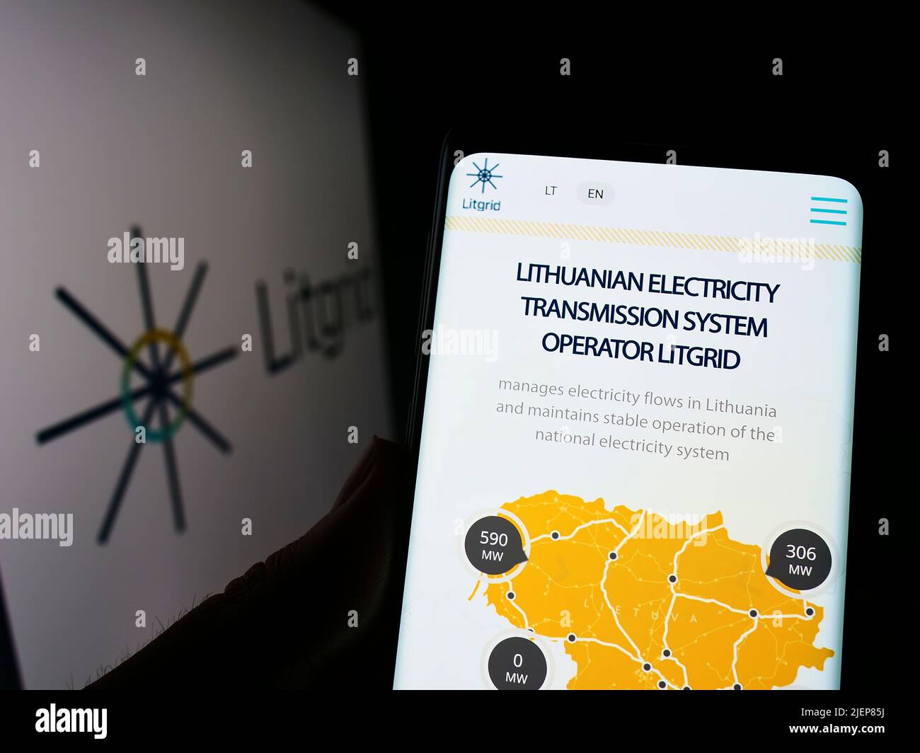 Person, die Mobiltelefon mit der Webseite des litauischen Elektrizitätsunternehmens Litgrid ab auf dem Bildschirm vor dem Logo hält. Konzentrieren Sie sich auf die Mitte des Telefondisplays. Stockfoto