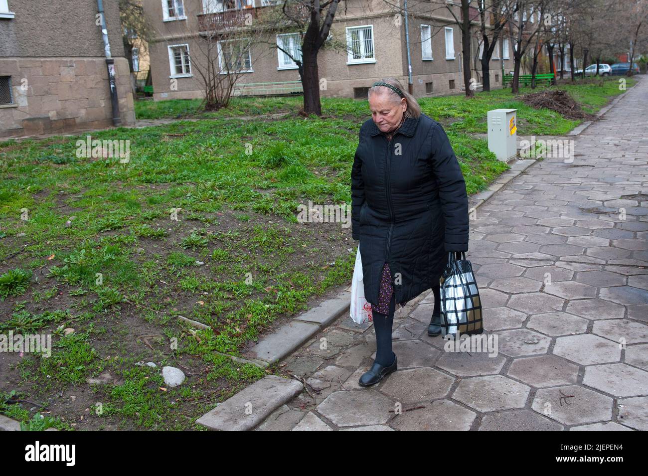 Sofia, Bulgarien, ältere und ältere Erwachsene Frau, die nach dem Kauf ihrer täglichen Lebensmittel und Lebensmittel nach Hause zum Supermarkt geht, während sie in einem Vorort im Sowjetstil der Hauptstadt des Landes lebt. Stockfoto