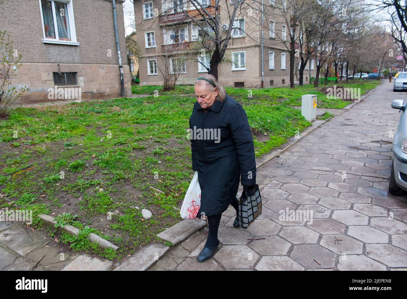 Sofia, Bulgarien, ältere und ältere Erwachsene Frau, die nach dem Kauf ihrer täglichen Lebensmittel und Lebensmittel nach Hause zum Supermarkt geht, während sie in einem Vorort im Sowjetstil der Hauptstadt des Landes lebt. Stockfoto