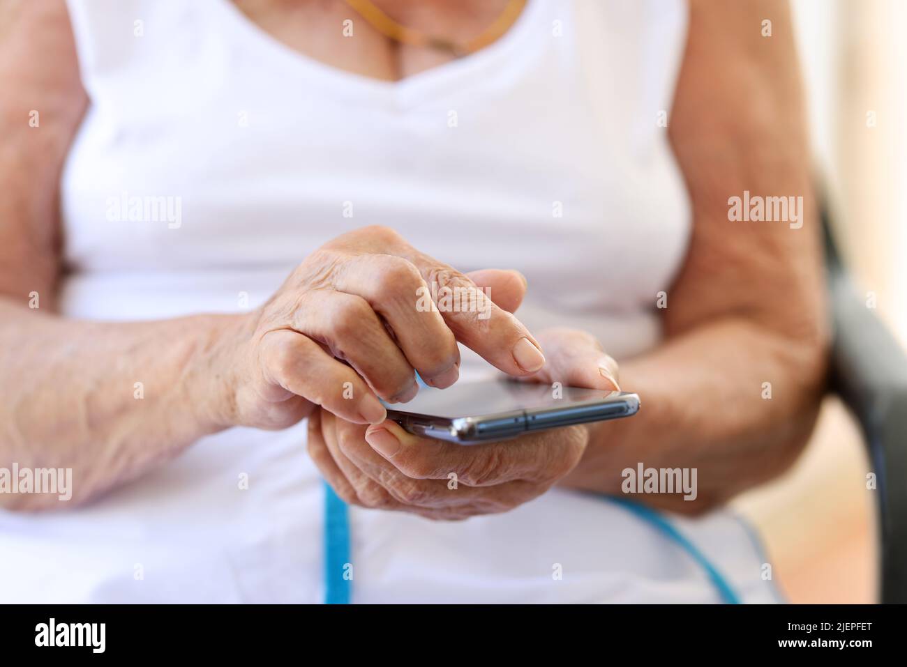 Nahaufnahme der Hände älterer Frau mit Smartphone Stockfoto