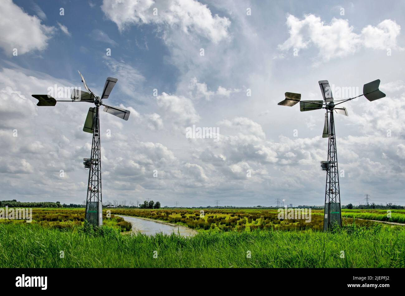 Zwei kleine moderne Windmühlen in einer Landschaft mit Sümpfen und Wiesen unter einem Himmel mit vereinzelten Wolken in der Region Noordwaard im Biesbosch National Par Stockfoto