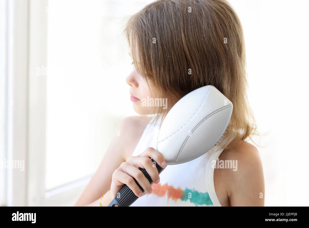 Kleines Mädchen kämmt Haare mit Kamm Nahaufnahme Stockfoto