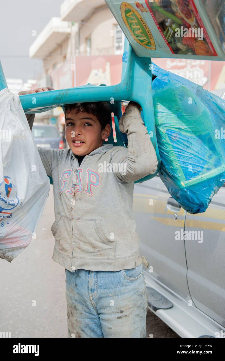 Al Mafraq, Jordanien. Viele Kinder und Jugendliche, oft Flüchtlings- und Migrantenkinder aus Syrien, dem Irak und Ägypten, müssen auf den Straßen innerhalb der informellen Wirtschaft hart arbeiten, um ihren Familien dabei zu helfen, einen Mindestlebensstandard zu erreichen, der oft unter die Armutsgrenze fällt. Stockfoto