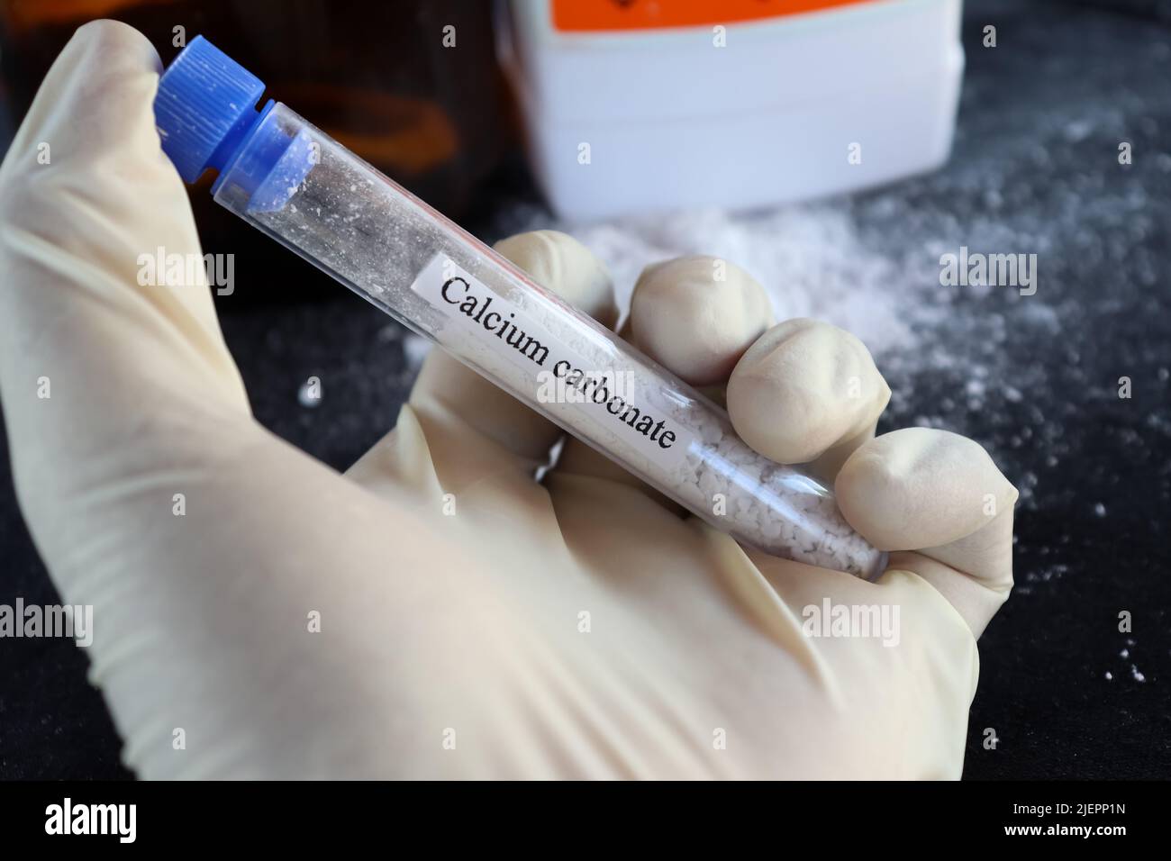 Calciumcarbonat im Reagenzglas und schwarzer Hintergrund Stockfoto