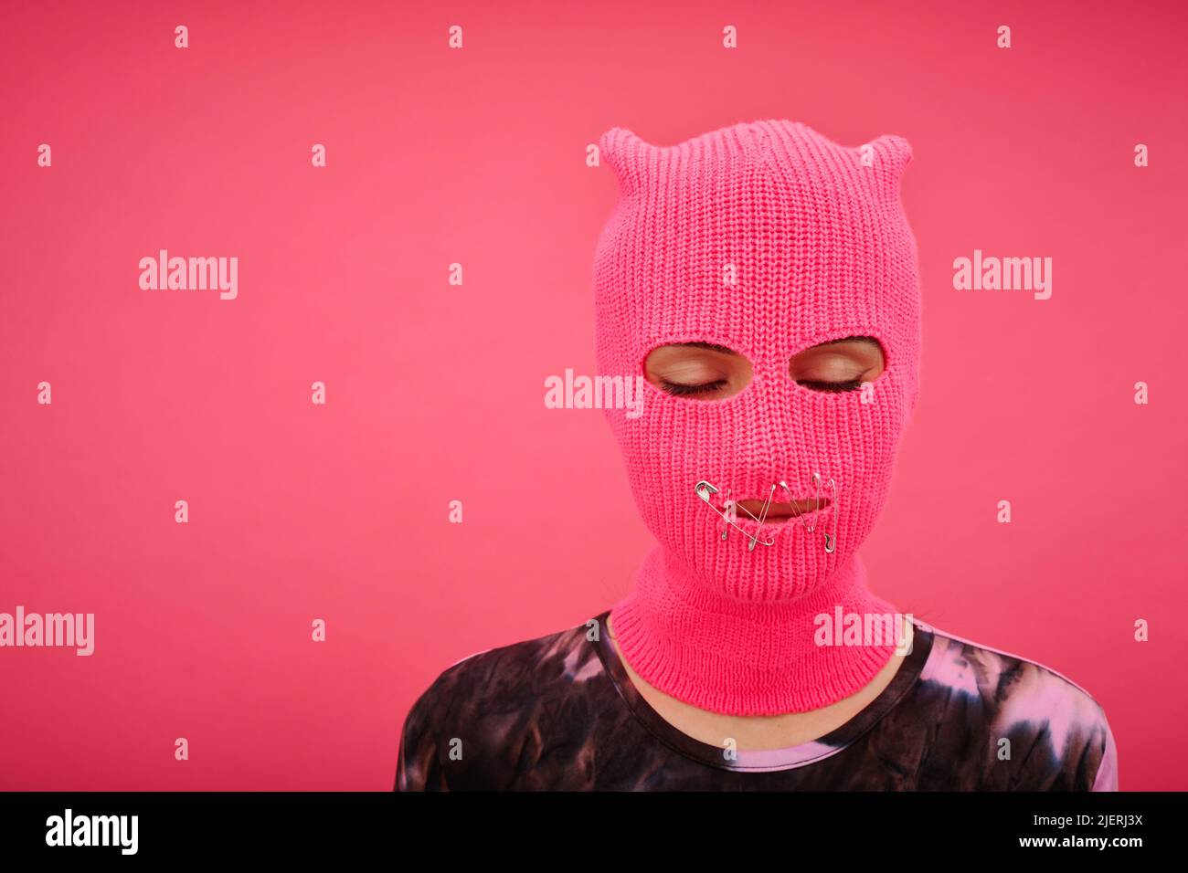 Porträt von Yung Mädchen in rosa Balaclava mit geschlossenem Mund und Augen ohne Rechte isoliert auf p Stockfoto